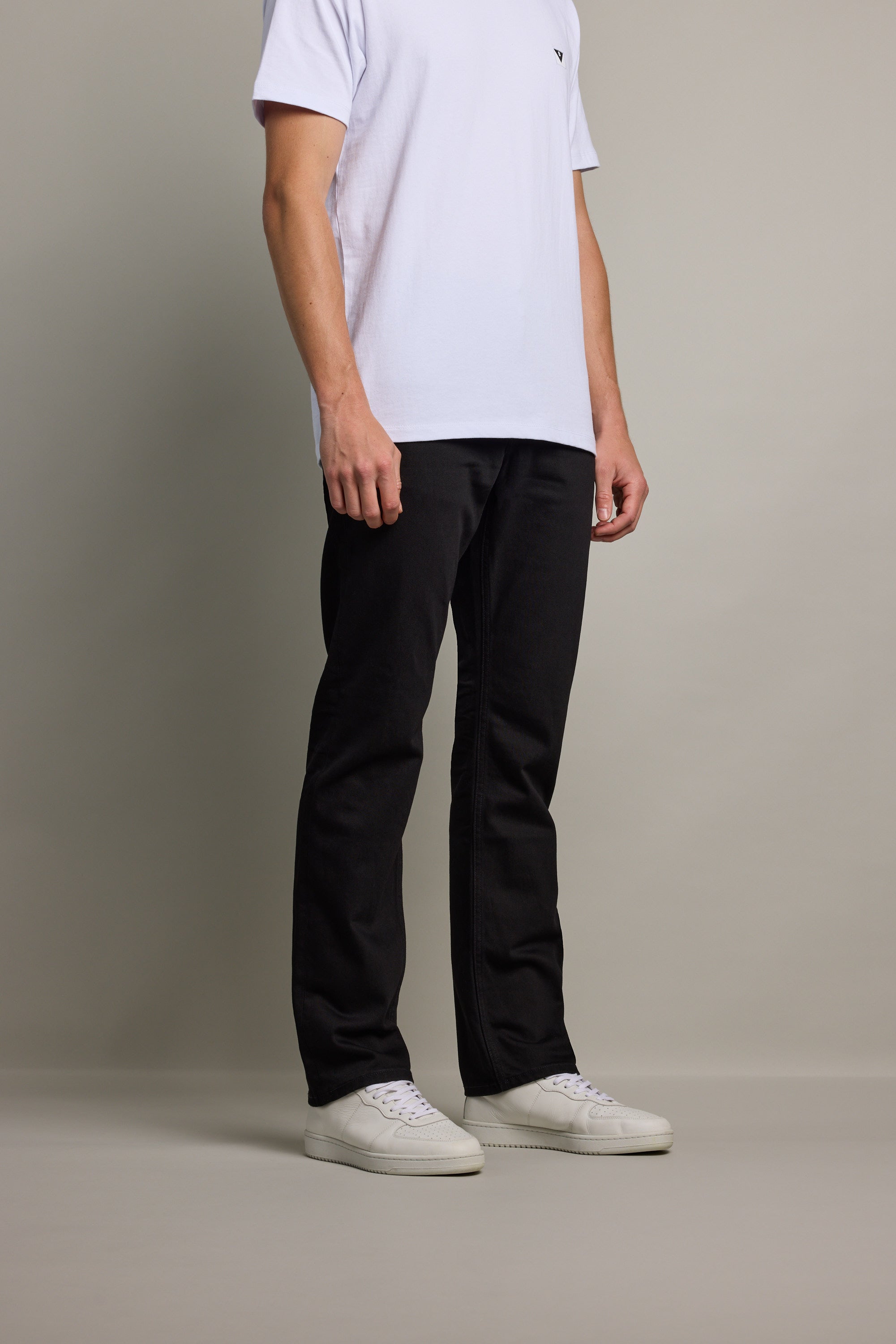A man in a white t-shirt and Barkers Wanderer Denim Straight Jean stands against a plain background.