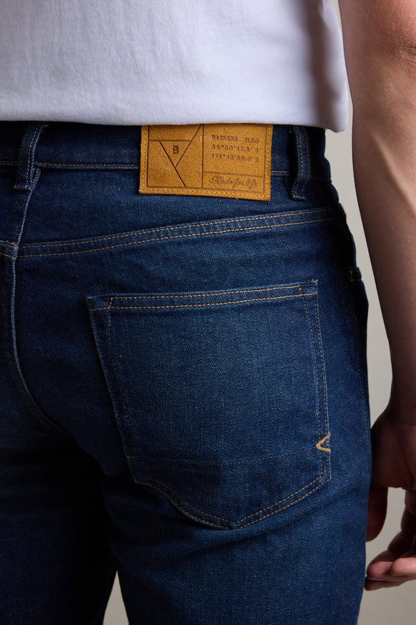 Person in Barkers Nomad Denim Taper Jean with a brown leather patch and white shirt.