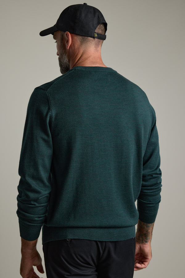 Man in a green Barkers Skyland ZQrx Merino Crew sweater and black cap, seen from behind.