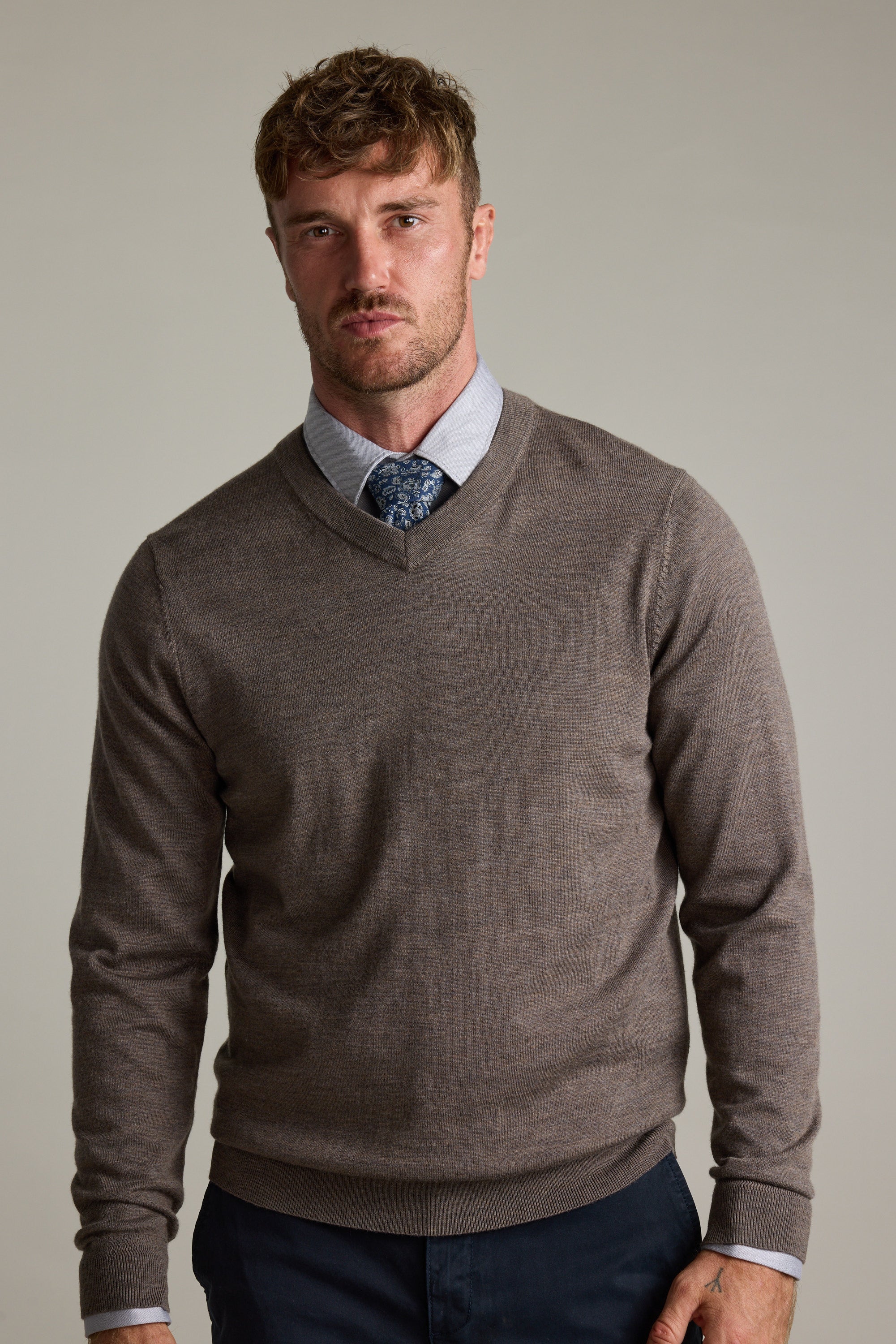 Man in Barkers Skyland ZQrx Merino Vee sweater over shirt and tie, plain background.