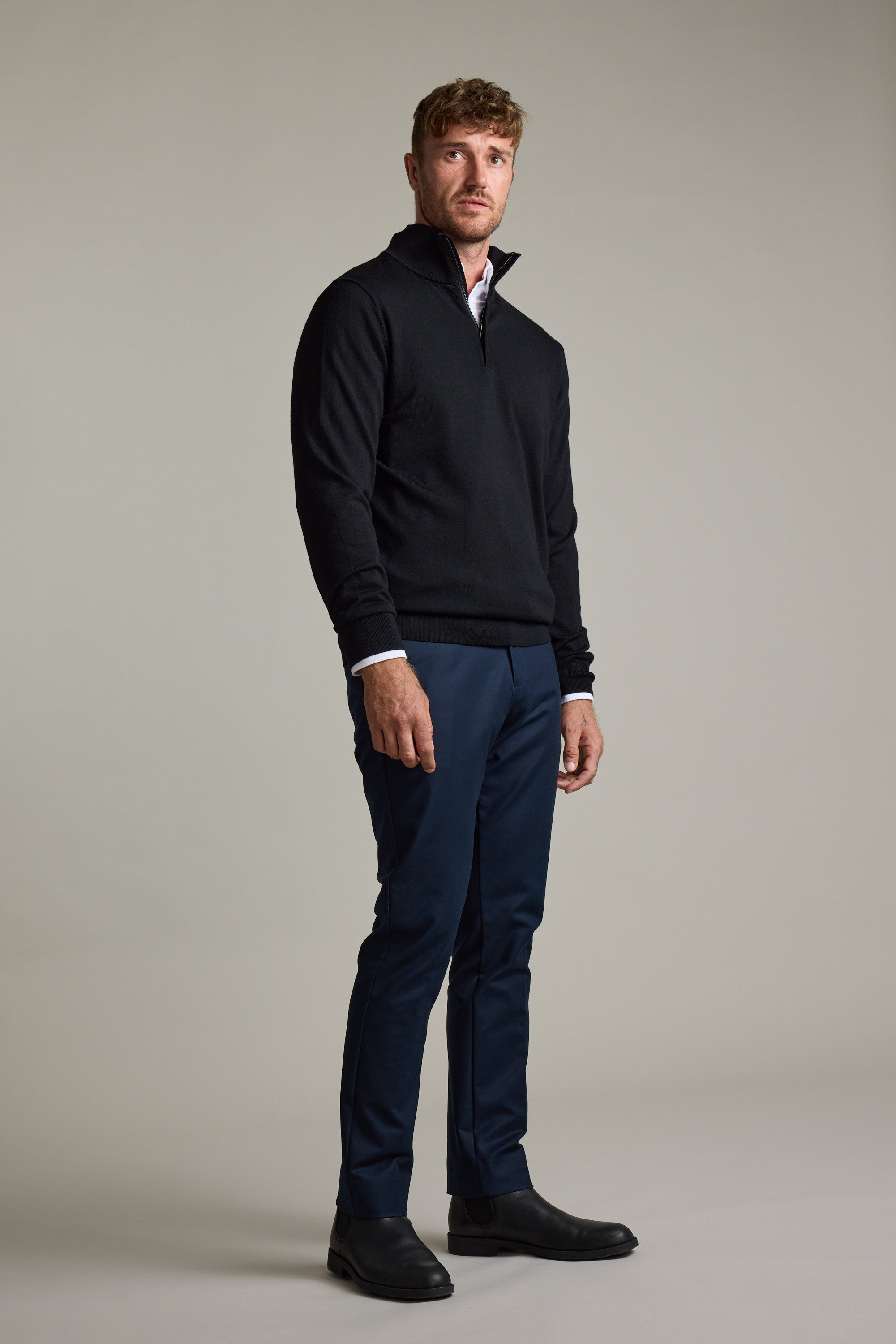 Man in Barkers Skyland ZQRX Merino 1/4 Zip, blue pants, black shoes, standing indoors.