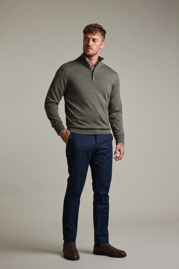 Man in a gray Barkers Skyland ZQRX Merino 1/4 Zip, navy pants, and brown boots.