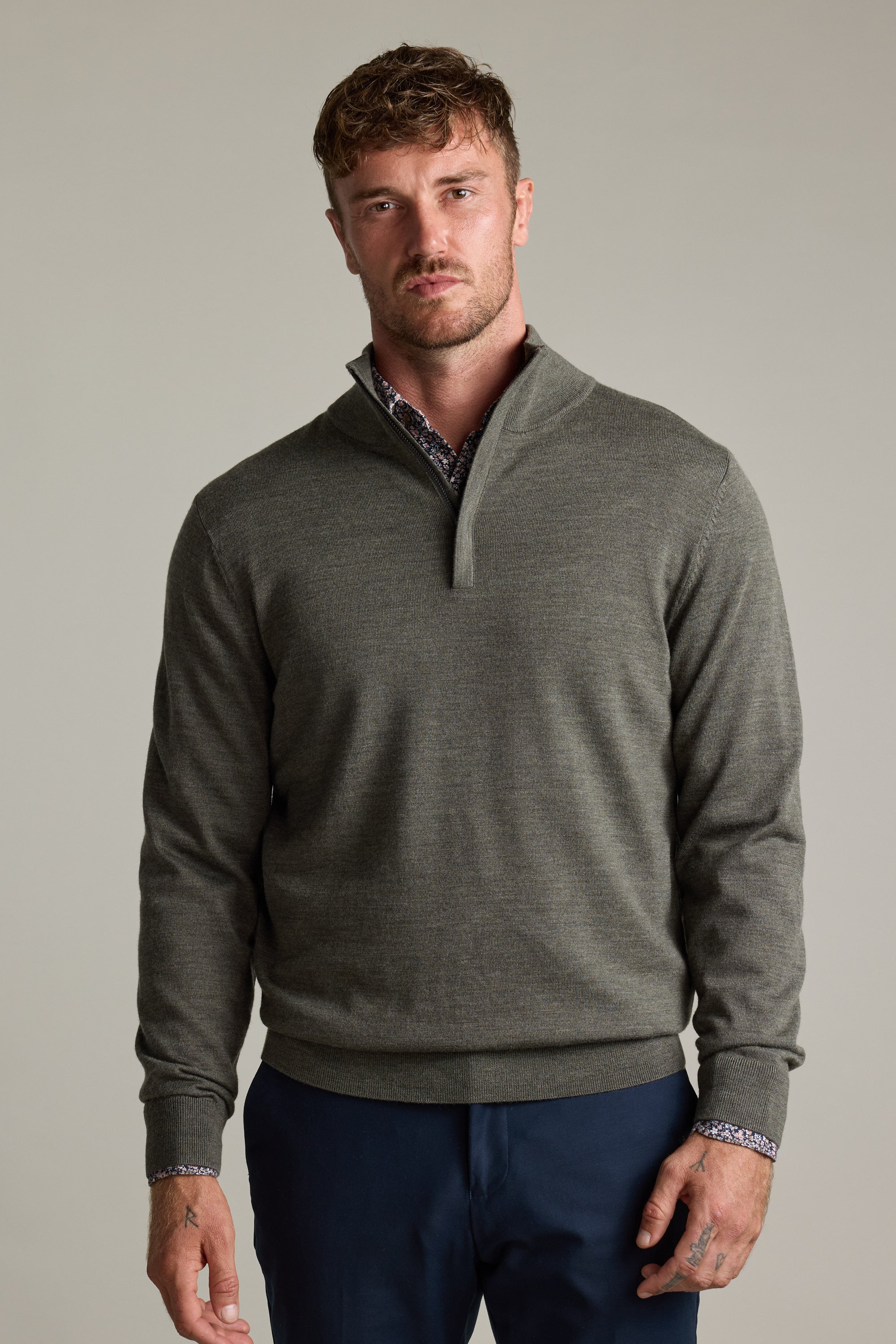 Man wears Barkers Skyland ZQRX Merino 1/4 Zip and navy pants against a plain background.