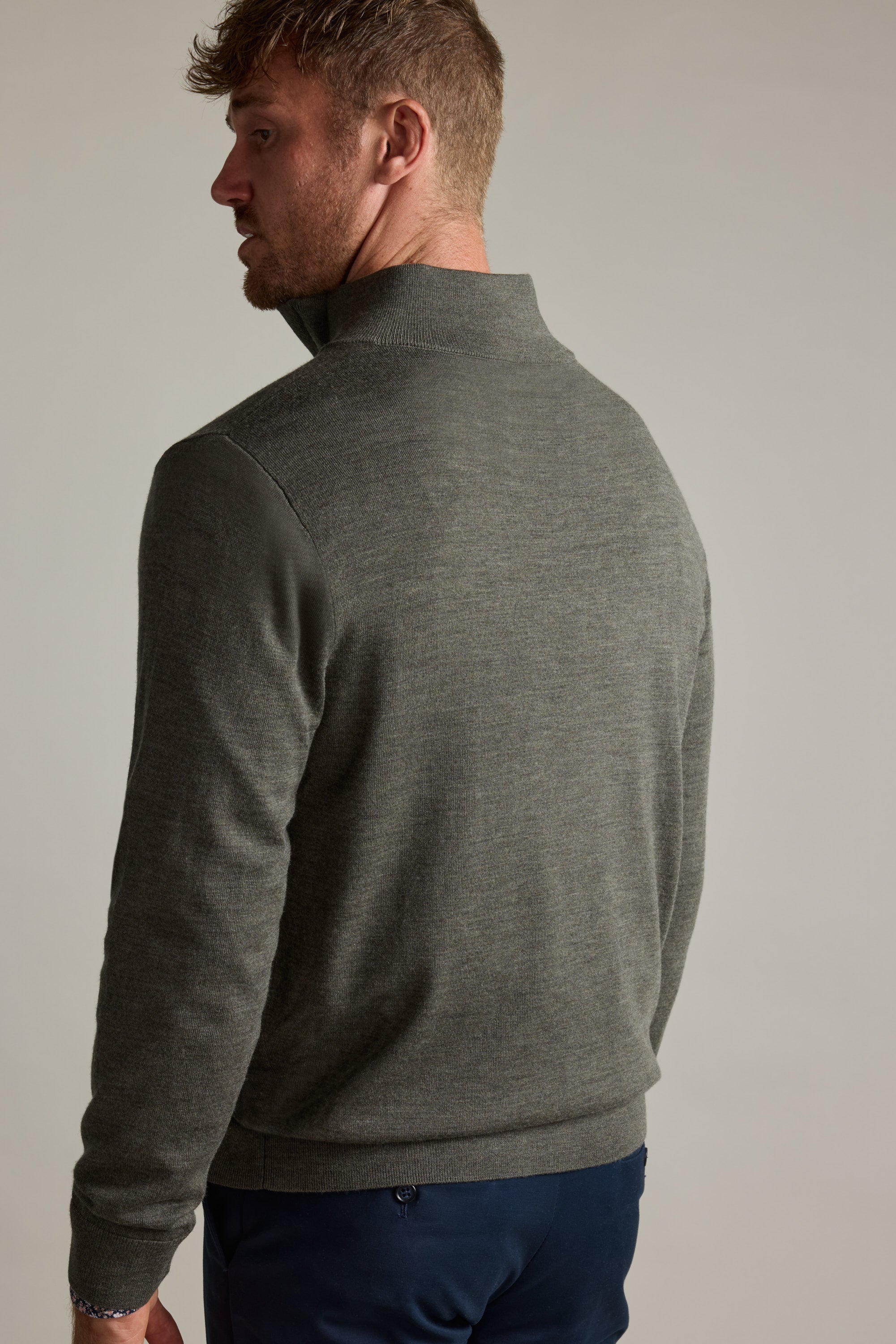 Man in Barkers Skyland ZQRX Merino 1/4 Zip, facing away, looking over his shoulder.