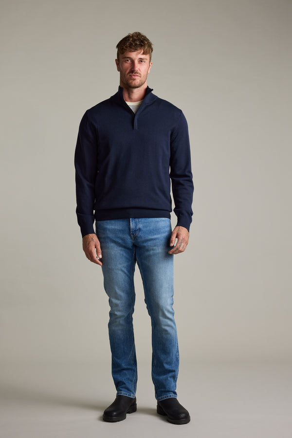 Man in blue jeans, Barkers Skyland ZQRX Merino 1/4 Zip pullover, and black shoes.