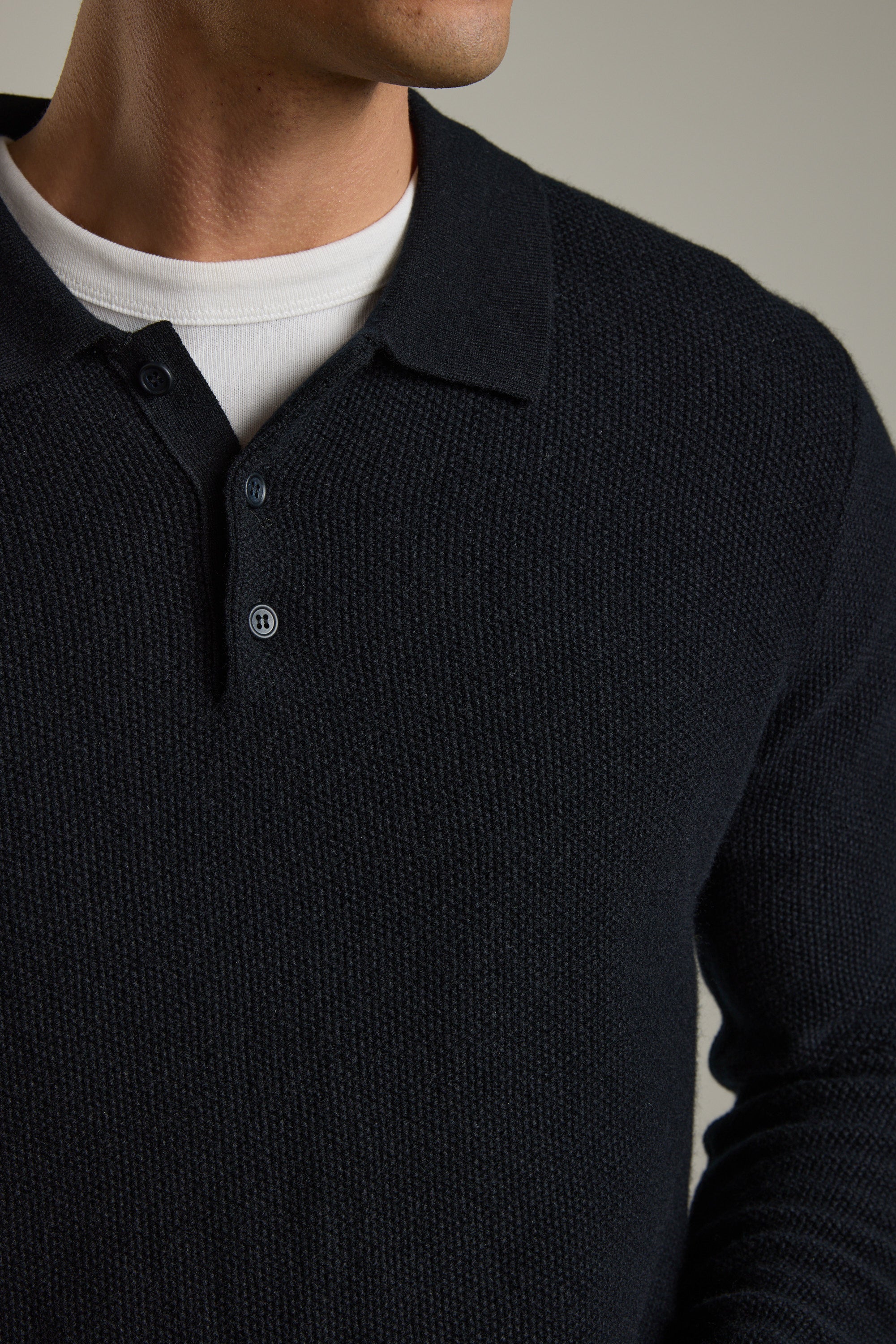 Man in Barkers Ainsley Woollen Long Sleeve Polo over white crew-neck; face partly visible.
