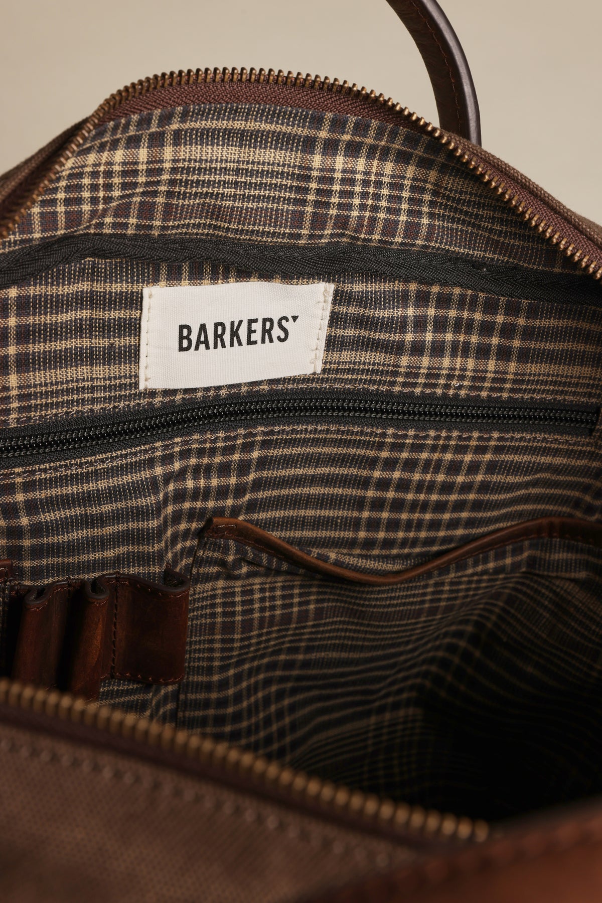 Open brown Redford Canvas Laptop Bag by Barkers with plaid lining and multiple inner pockets.