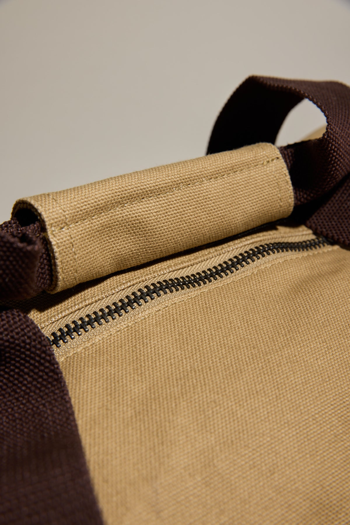 Close-up of a brown zipper on a Barkers Canvas Duffle Bag with dark brown straps.