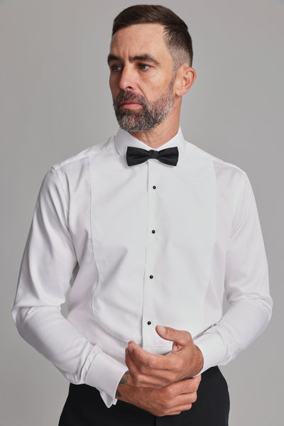 Man in a Barkers Eldridge Dress Shirt and formal wear, looking to the side on gray background.