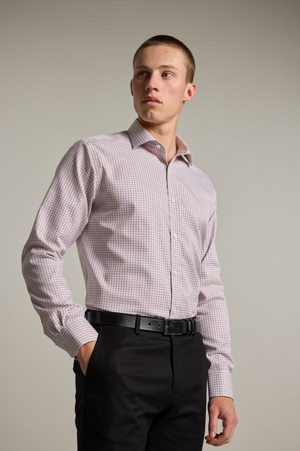 A man wears the Barkers Marbury Check Business Shirt and black pants, standing with one hand in his pocket and looking confidently to the side against a plain background.