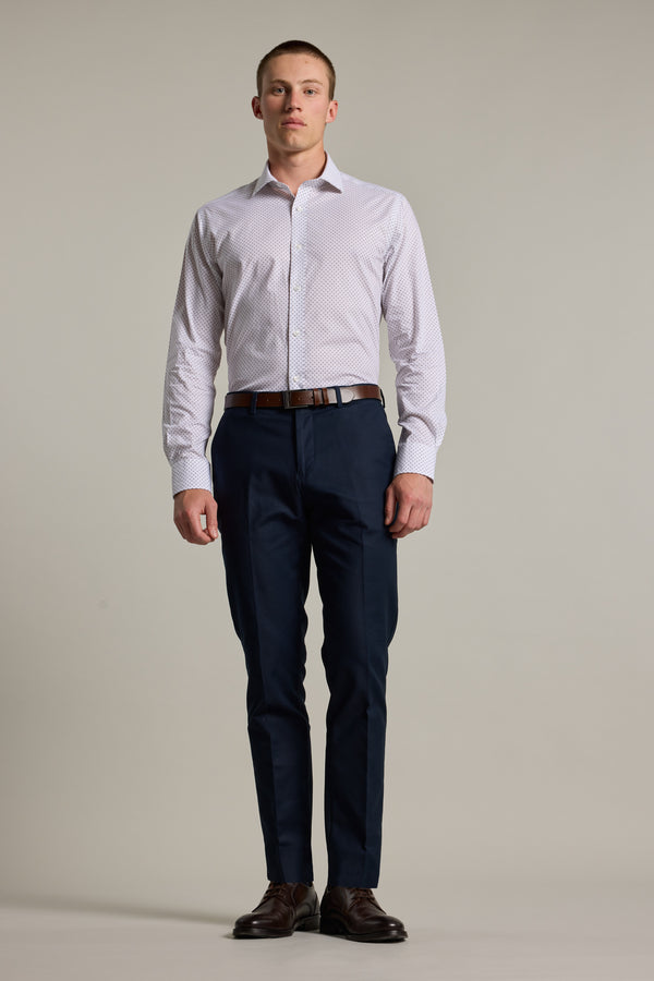 A man stands against a plain light background wearing the Barkers Foster Print Business Shirt, paired with dark blue dress pants, a brown belt, and dark dress shoes. He faces forward with a neutral expression and relaxed posture.