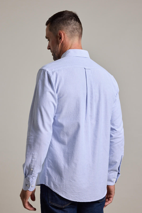 A man with short hair, seen from behind, wears the Barkers Maynard Oxford Stripe Shirt in light blue and white cotton and dark jeans against a plain background.