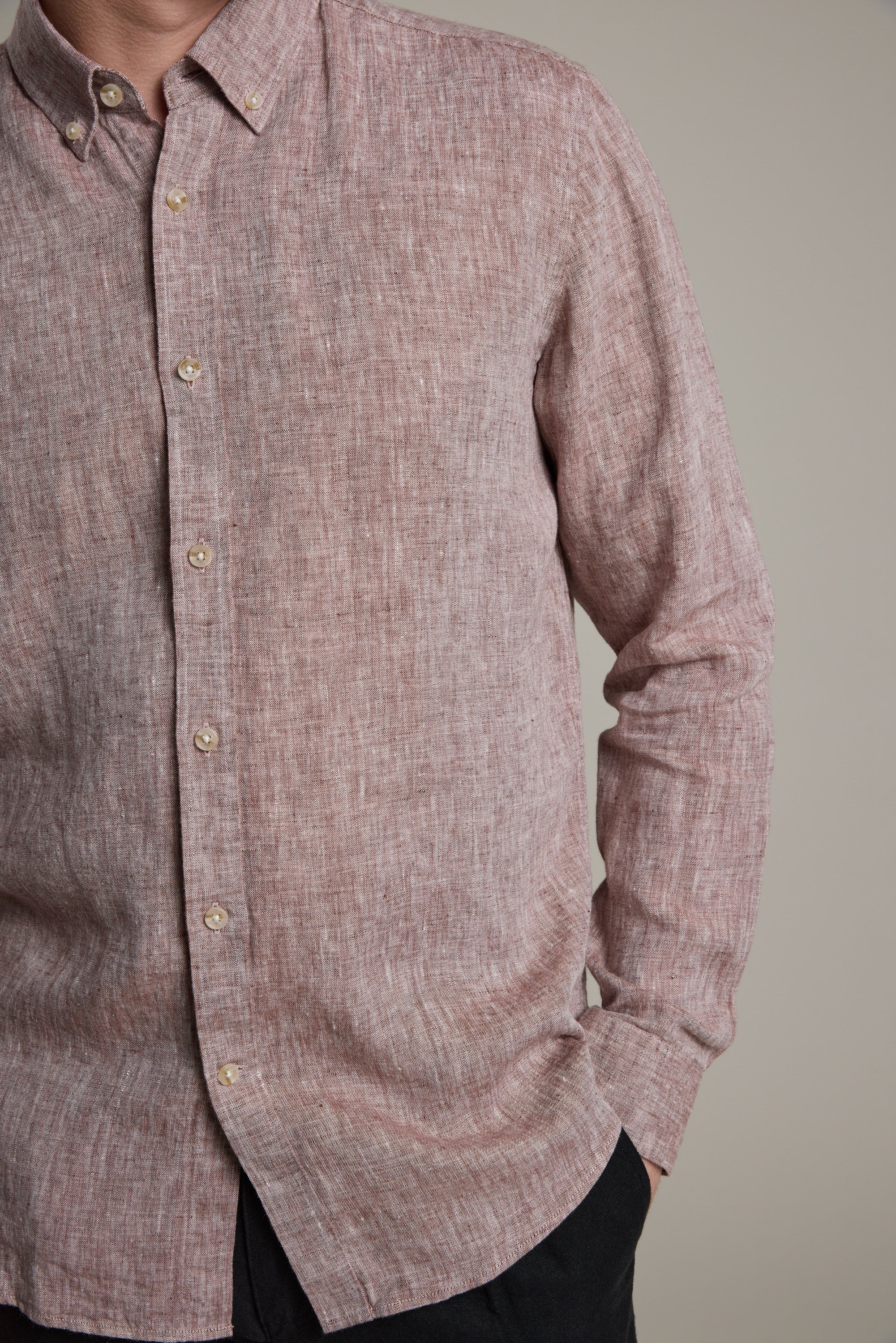 A person models the Barkers Dorset Linen Shirt, a long-sleeved, tailored-fit French linen shirt in light reddish-brown. Only their upper body is visible against a plain background, with their face partly out of frame.