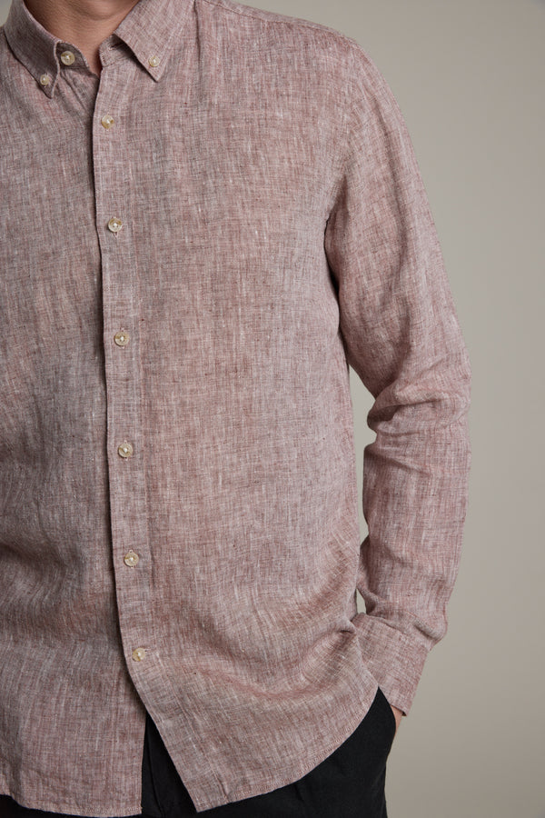 A person models the Barkers Dorset Linen Shirt, a long-sleeved, tailored-fit French linen shirt in light reddish-brown. Only their upper body is visible against a plain background, with their face partly out of frame.