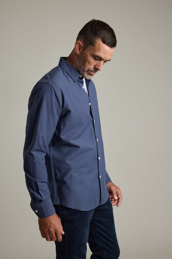 Man wears Barkers Maynard Oxford Shirt, looking down against a plain light background.