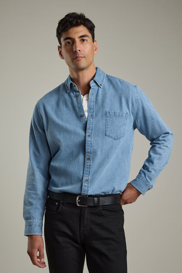 Man in Barkers Avalon Denim Shirt and black jeans stands against a plain background.