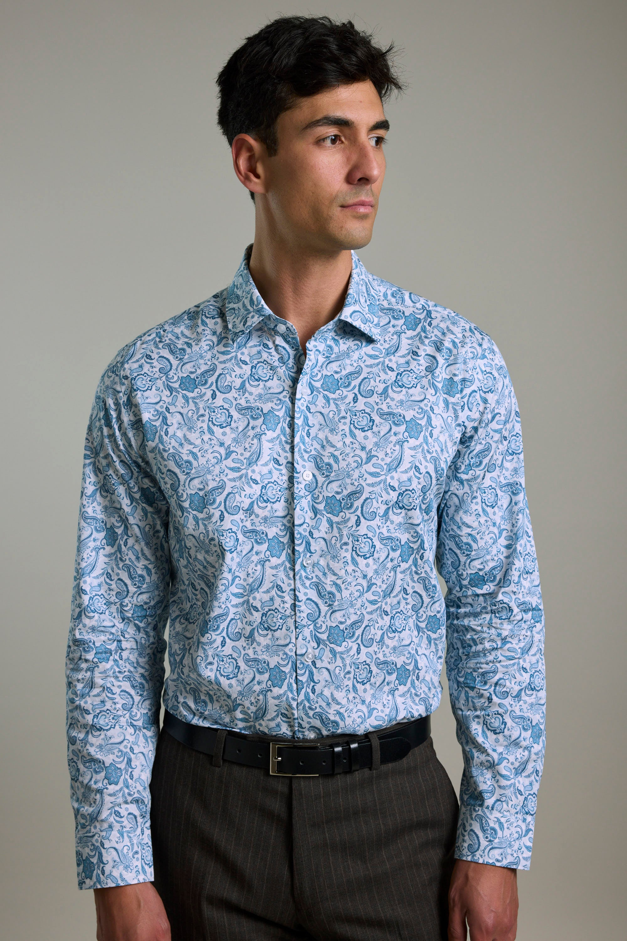 Man in Barkers Ronton Print Business Shirt and brown pants, looking to the side.