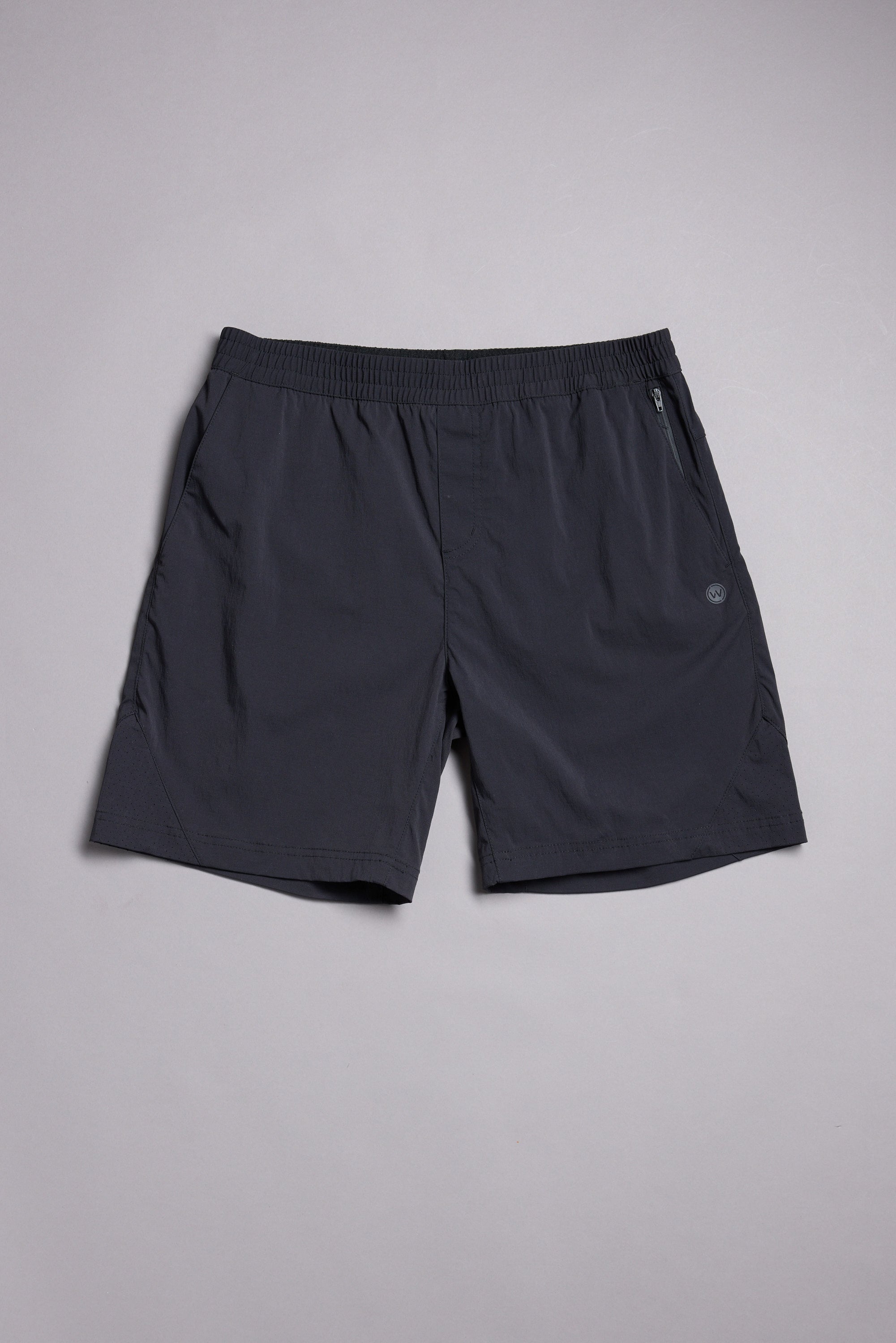 The WearEver Agile Short by WearEver is a dark gray, lightweight stretch short with a 7-inch inseam, elastic waistband, side pockets, and a small logo on the left leg, shown laid flat on a light gray background.