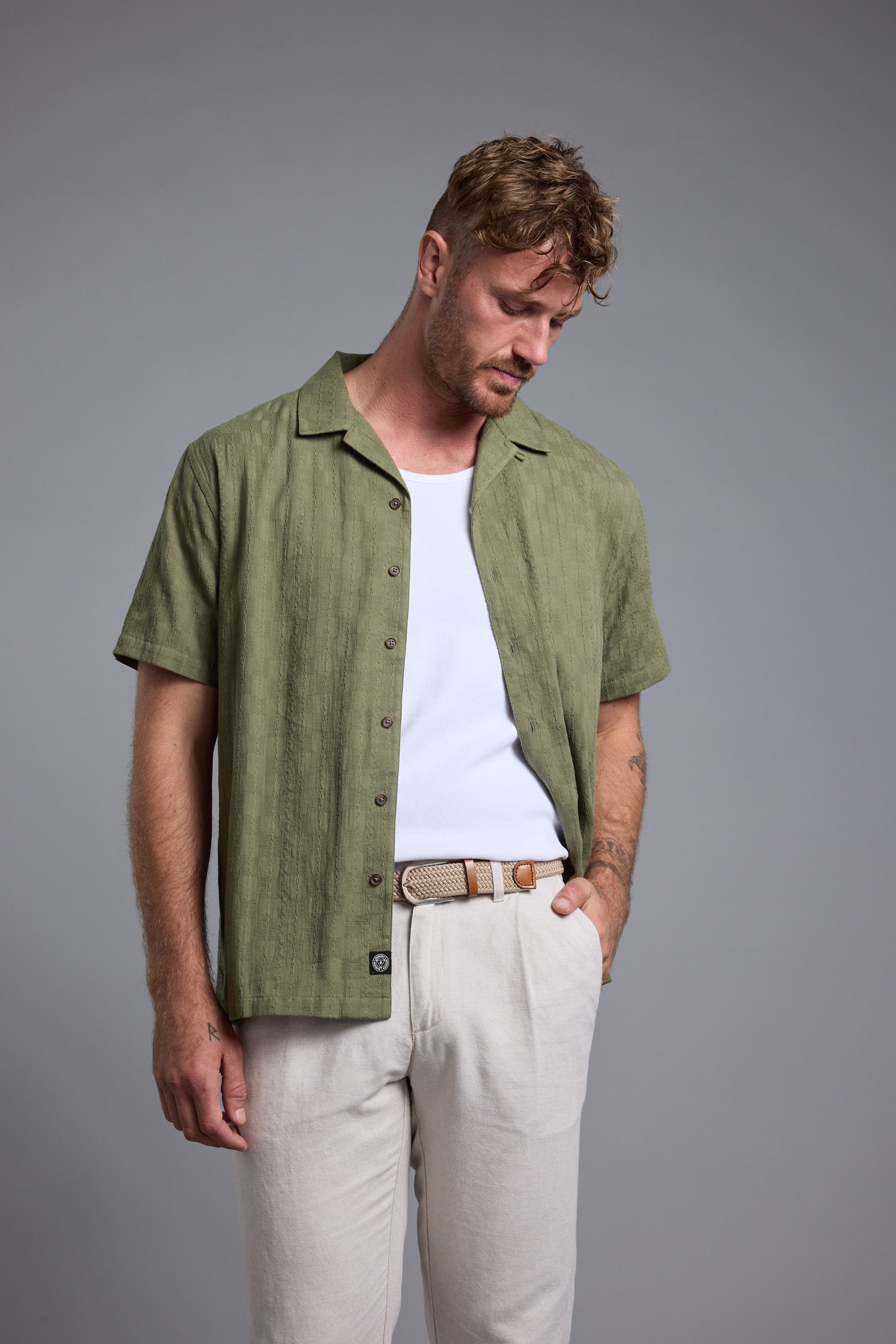 Man in Barkers Otis Stripe Cuban Shirt, white tee, beige pants—your summer essential look.