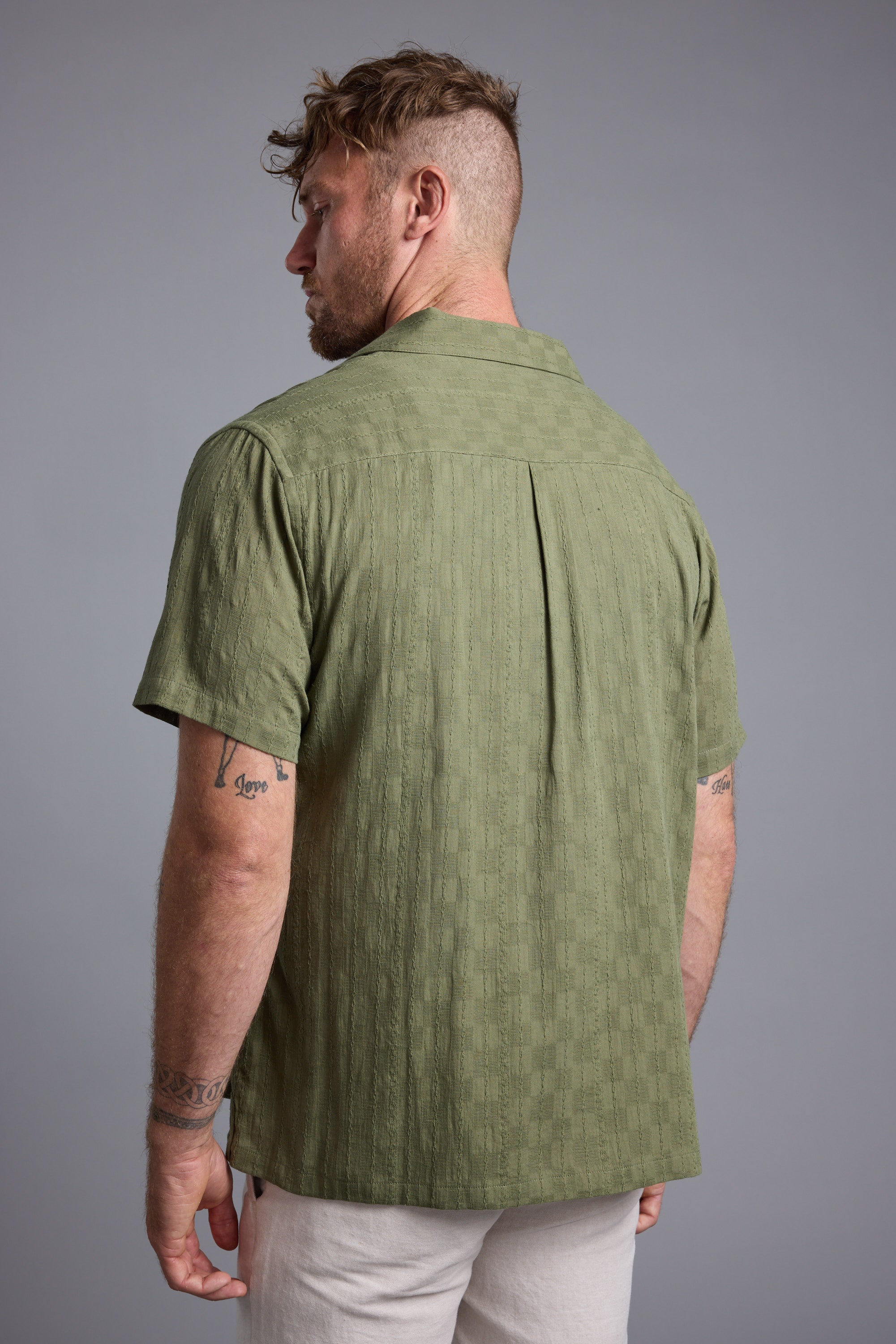 Man with short hair wearing a Barkers Otis Stripe Cuban Shirt, seen from the back.