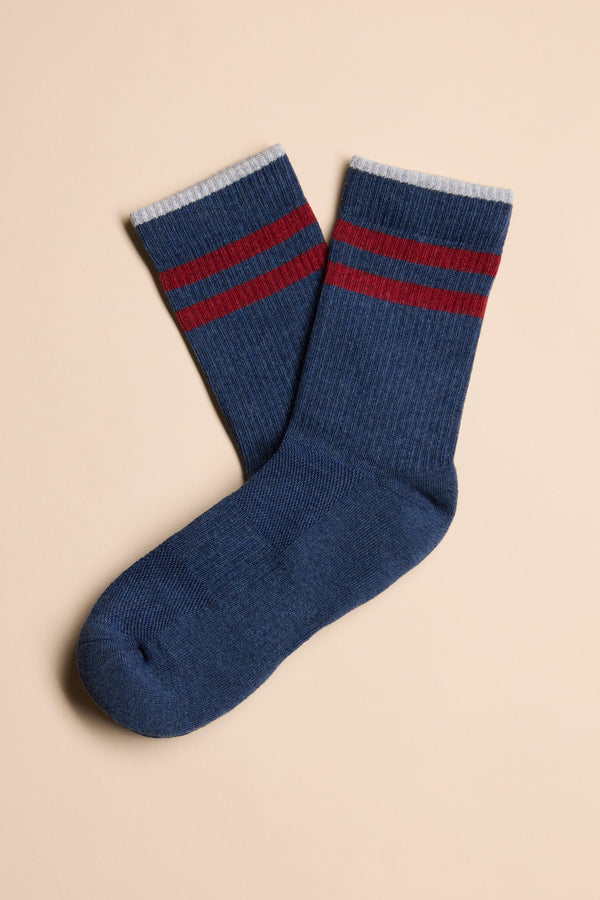 A pair of blue Barkers Emerson Sport Socks featuring two red stripes near the top and white cuffs, laid flat on a beige background.