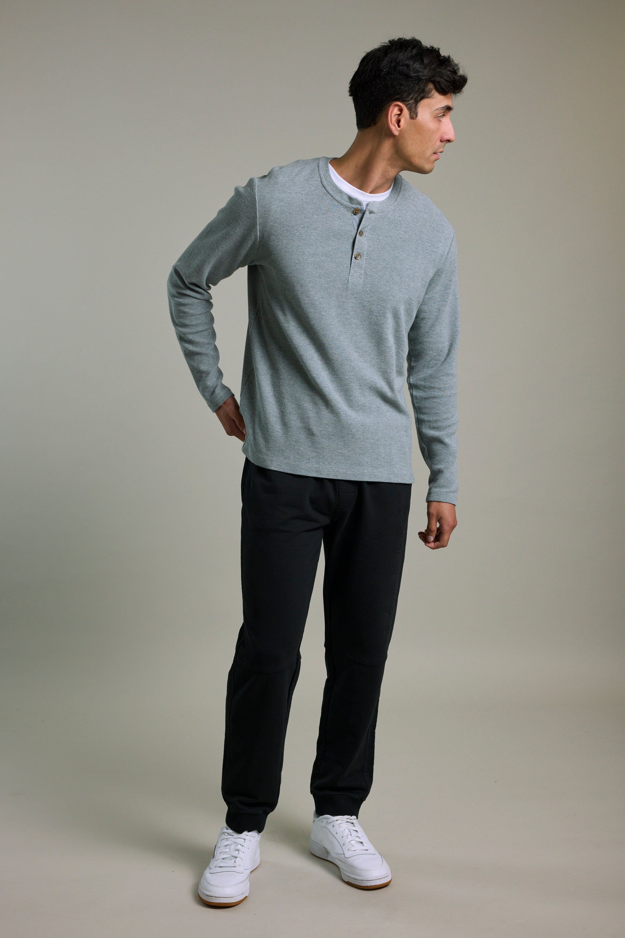 Man wears Barkers Organic Classic Print Track Pant, standing and looking to the side.