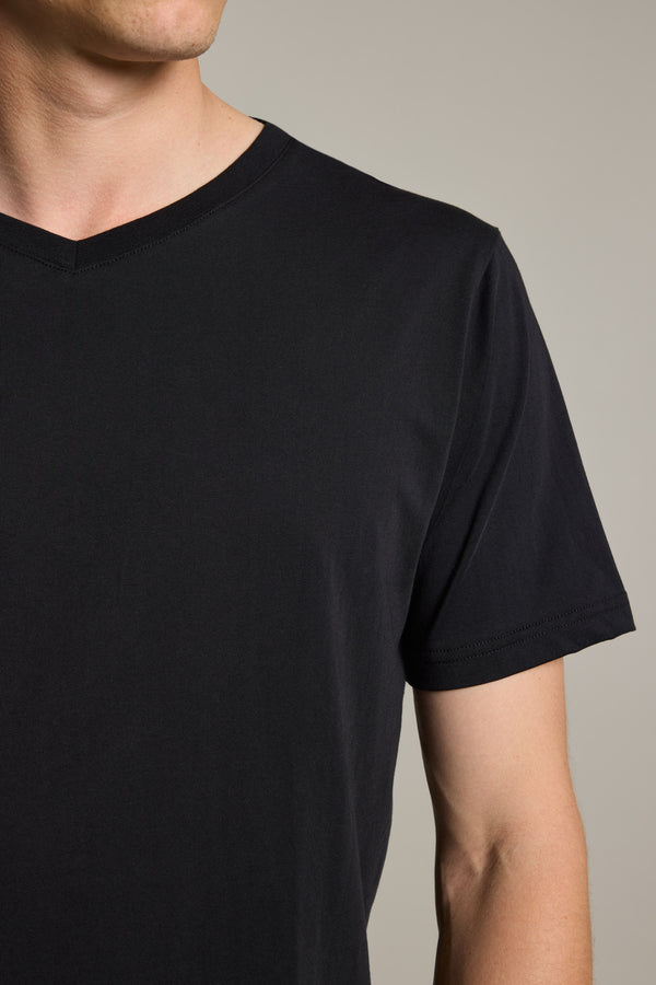 A person models the Barkers Organic Cotton V Neck Tee, shown from shoulders to mid-torso against a neutral backdrop. This mid-weight everyday staple appears with their face partially out of frame.