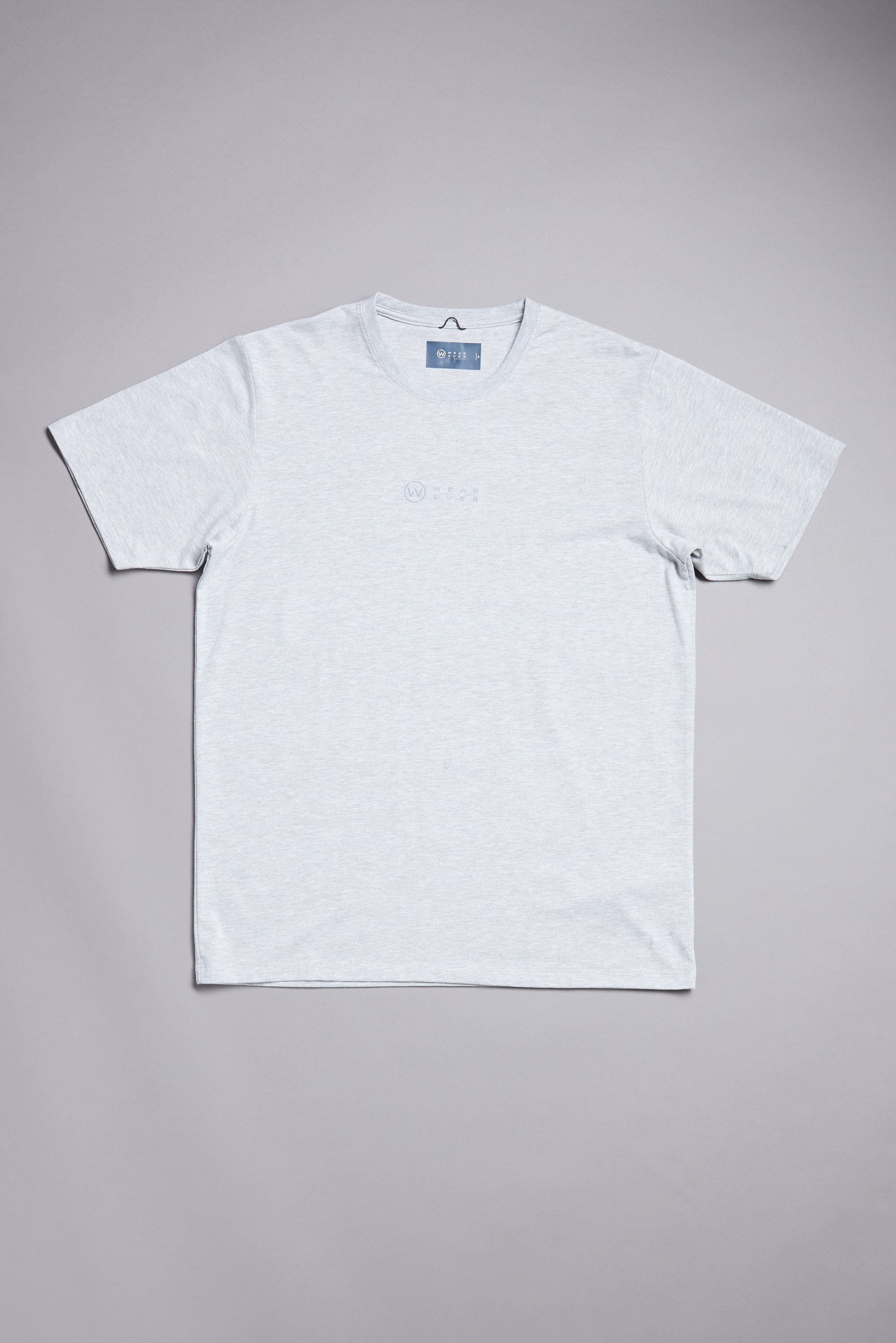 The WearEver Outbound T-Shirt by WearEver is a light grey short-sleeve performance tee with a small chest logo, laid flat on a grey background. This UPF t-shirt combines style and comfort for your everyday routine.