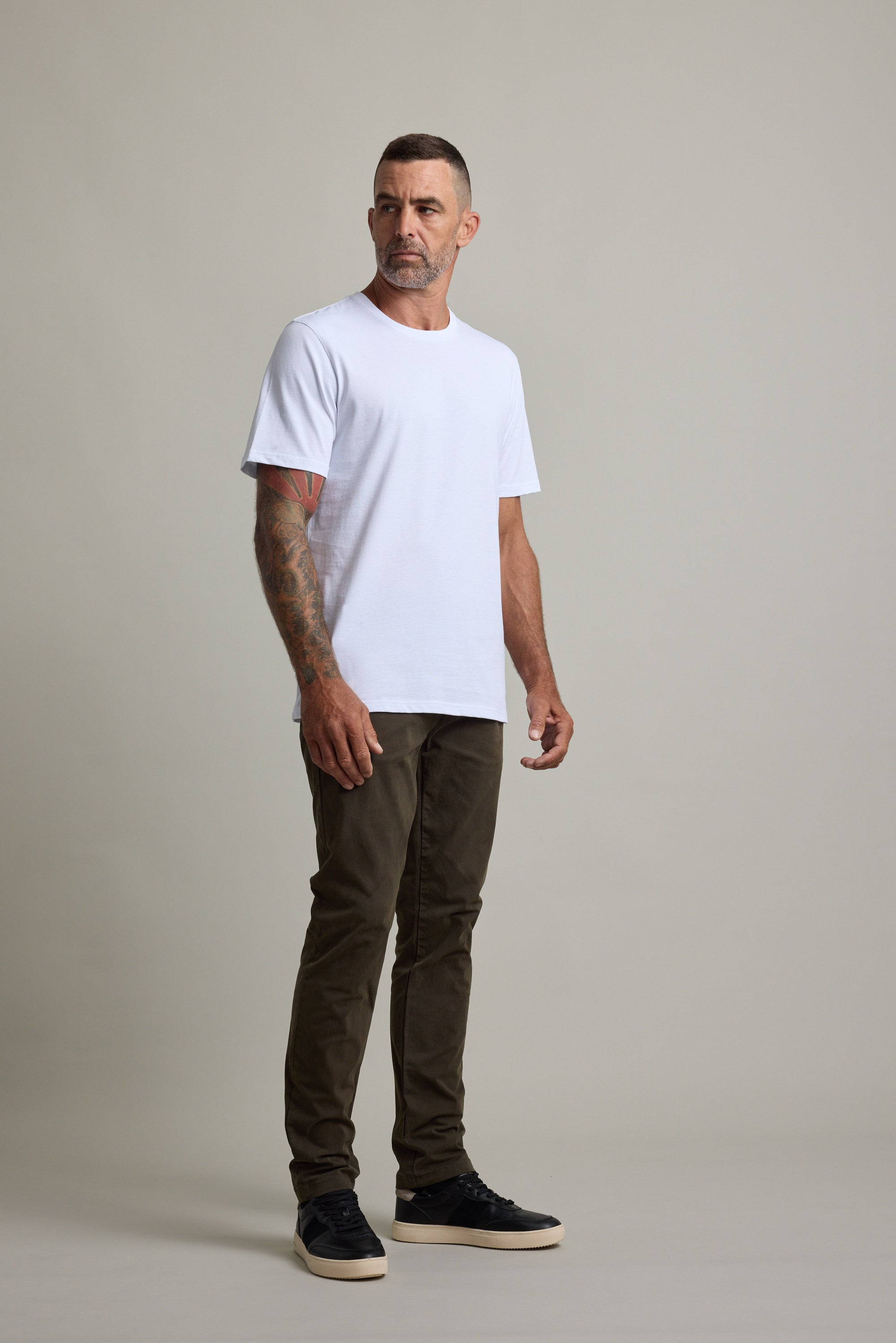 Man in a white Barkers Good Earth Cotton Essential Tee, brown pants, and black shoes.