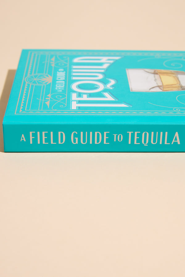 Other’s A Field Guide To Tequila, a turquoise book, rests on a beige surface.