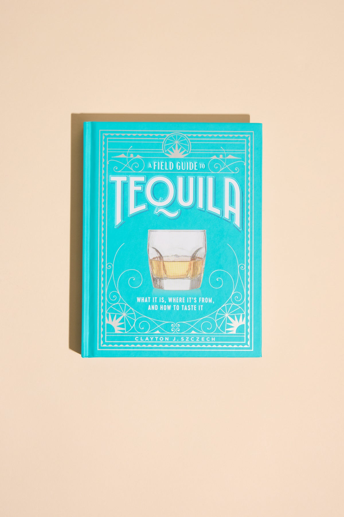 A Field Guide To Tequila by Other, turquoise cover, on a beige background.
