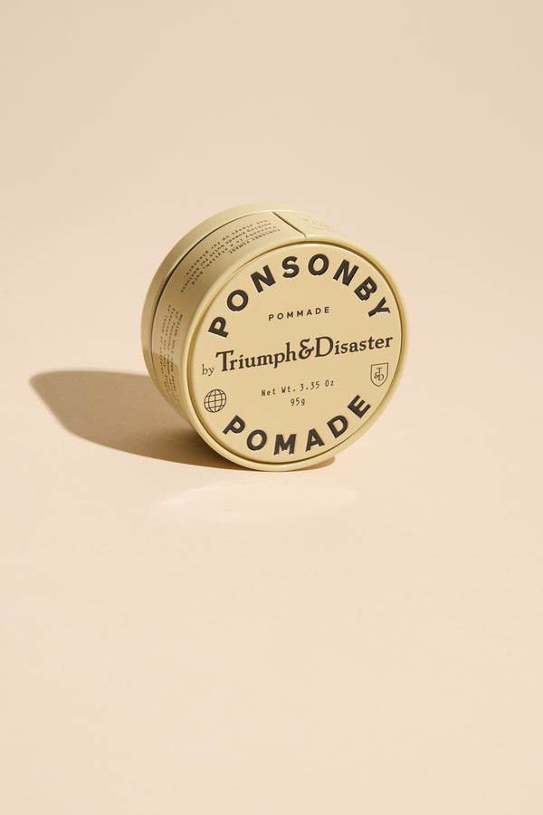 Triumph & Disaster Ponsonby Pomade tin for natural hair styling on a beige background.
