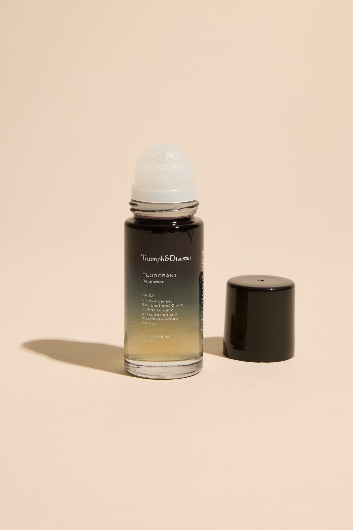 Triumph & Disaster Deodorant V1 Spice in glass roll-on bottle with black cap on beige background.