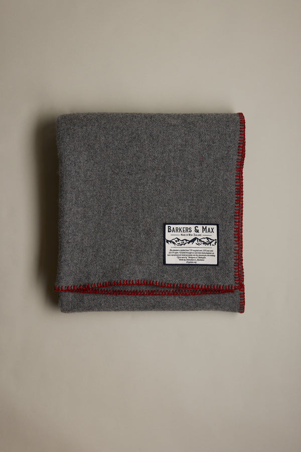 Folded gray Wool Take Back Blanket by Other, red stitching, Barkers & Max label on top.