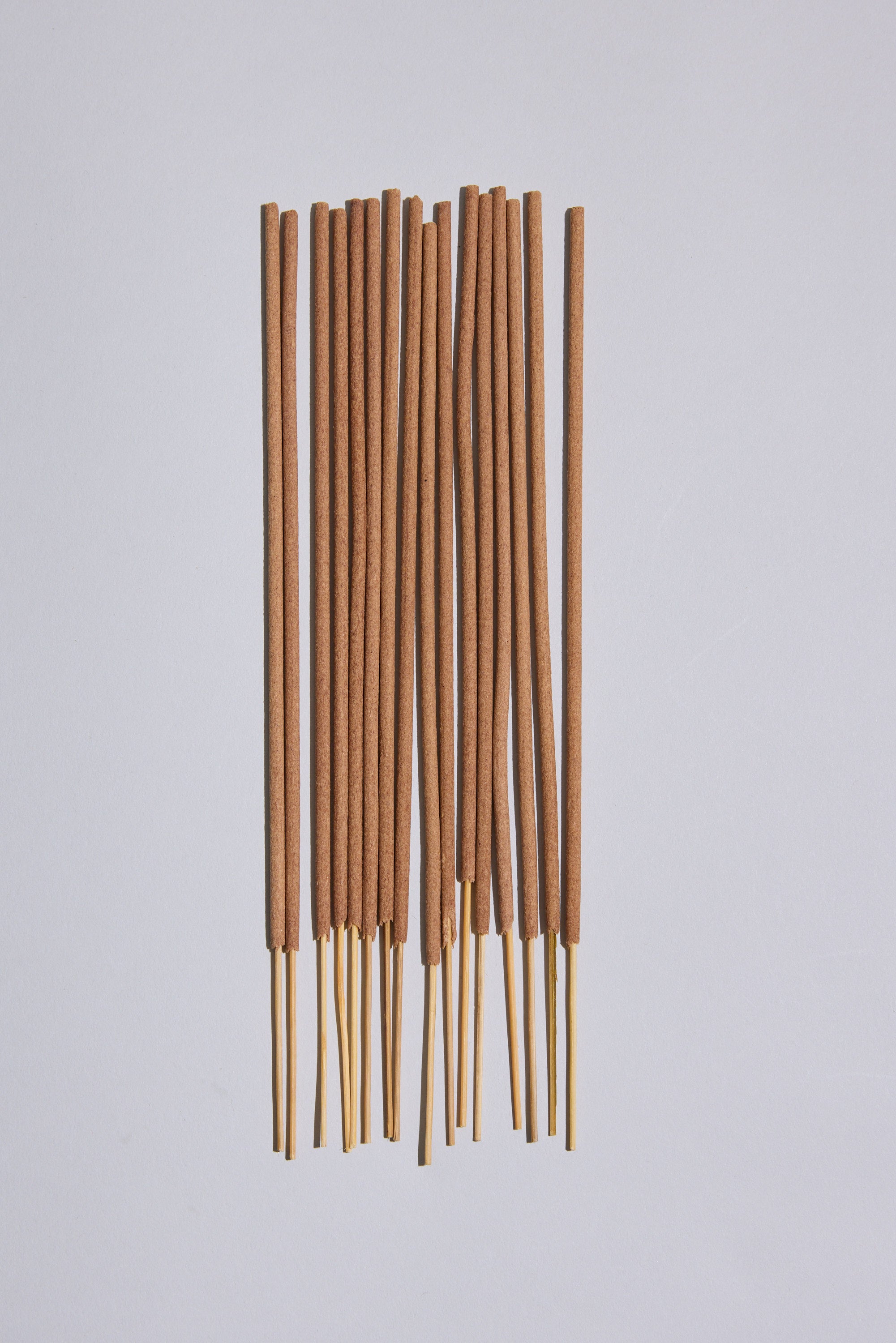 Several EoE Strand Incense Sticks by Earl of East are arranged parallel on a plain light surface, with their birchwood ends exposed at the bottom.
