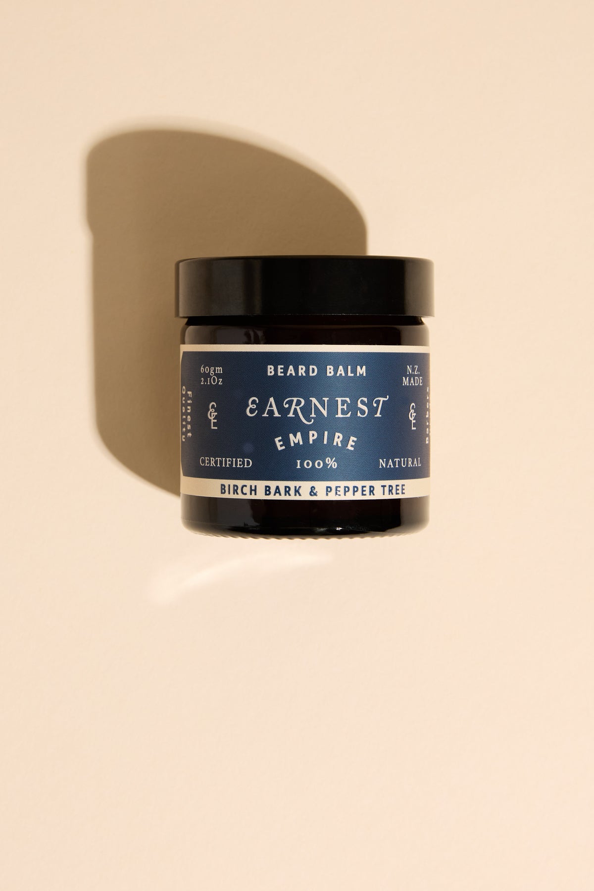 Earnest Empire Beard Balm, birch bark scent, on beige background with shadow.