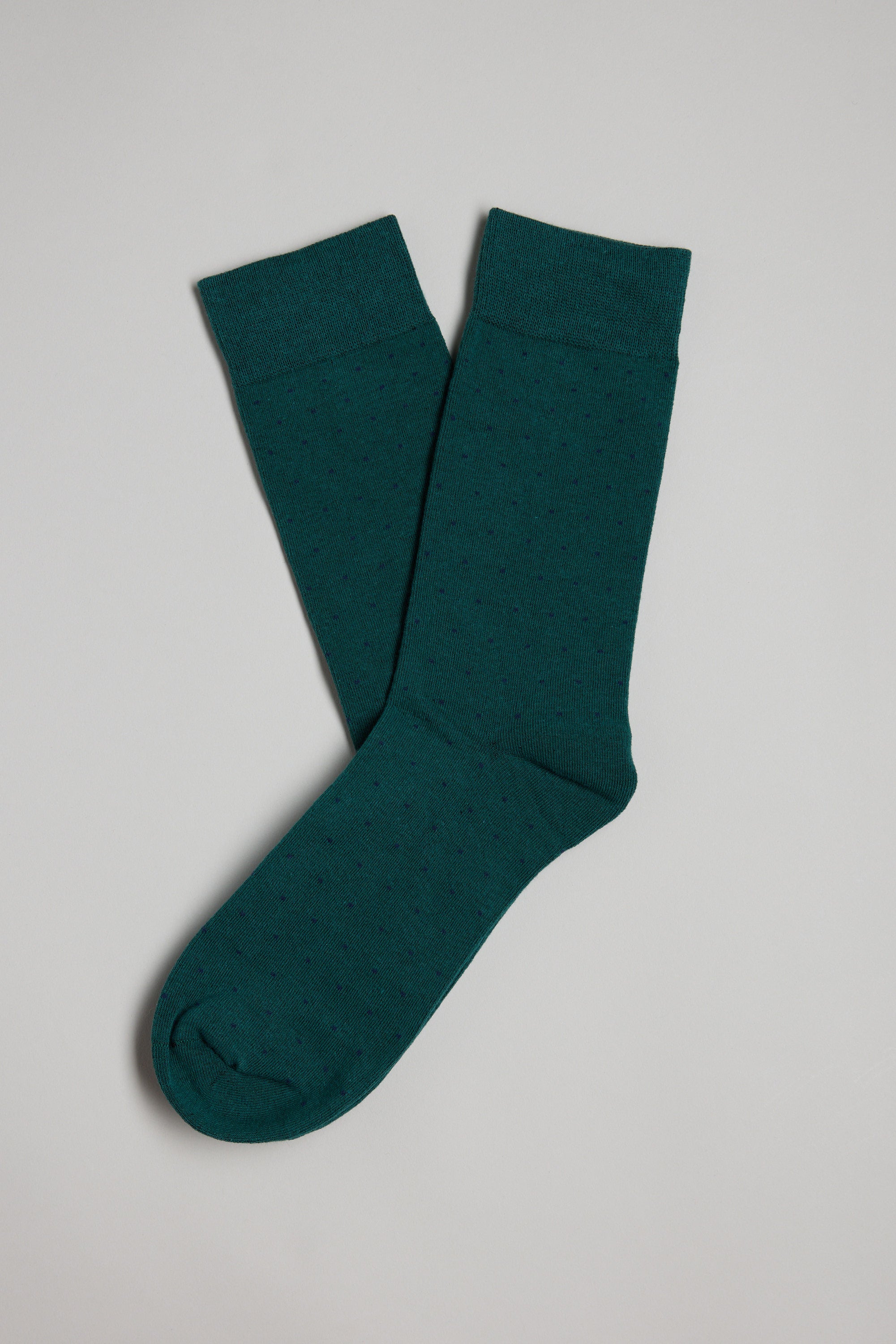 The Barkers Mercer Dot Sock features a subtle pin-dot pattern in dark green, shown laid flat on a light grey background.