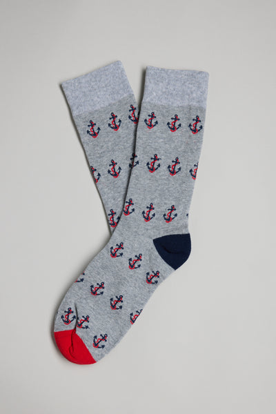 The Barkers Anchor Sock is a pair of men's grey cotton socks with red and navy anchor patterns, featuring a red toe on one sock and a navy toe on the other—making them the perfect gift.