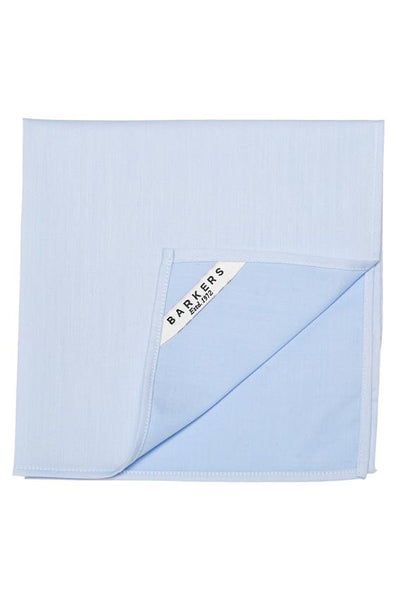 The Tribeca Pocket Square by Barkers is a light blue cotton accessory, neatly folded with one corner up to reveal a white label reading “Barkers Established 1972”—a timeless men's classic.
